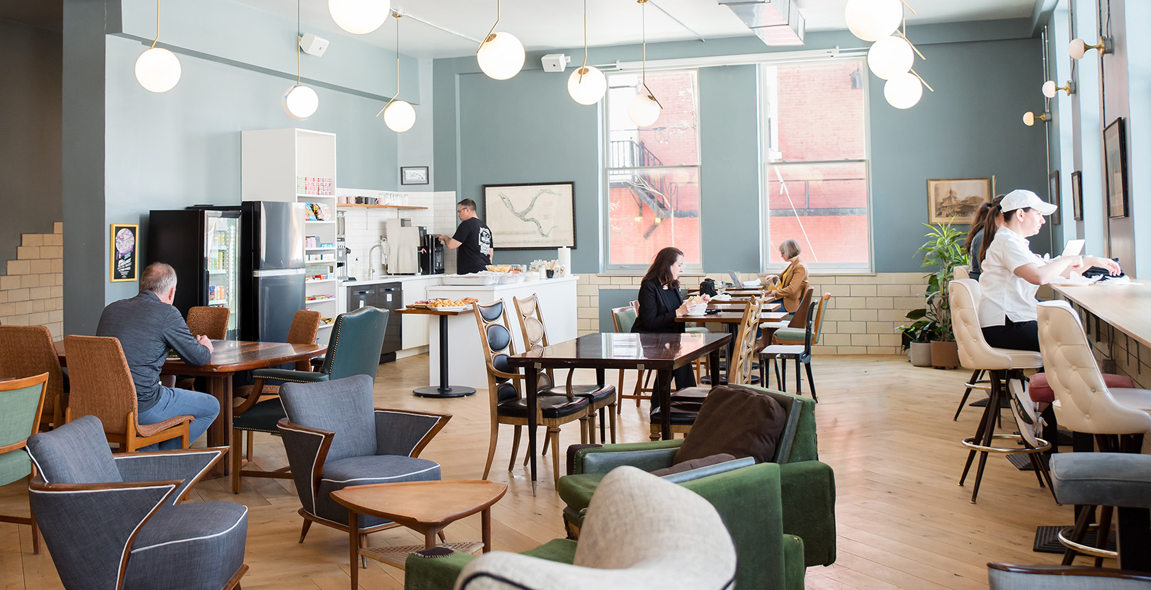 The Cafe at Fulton Commons coworking space Pittsburgh — open lounge with coffee bar, globe pendants, and natural light