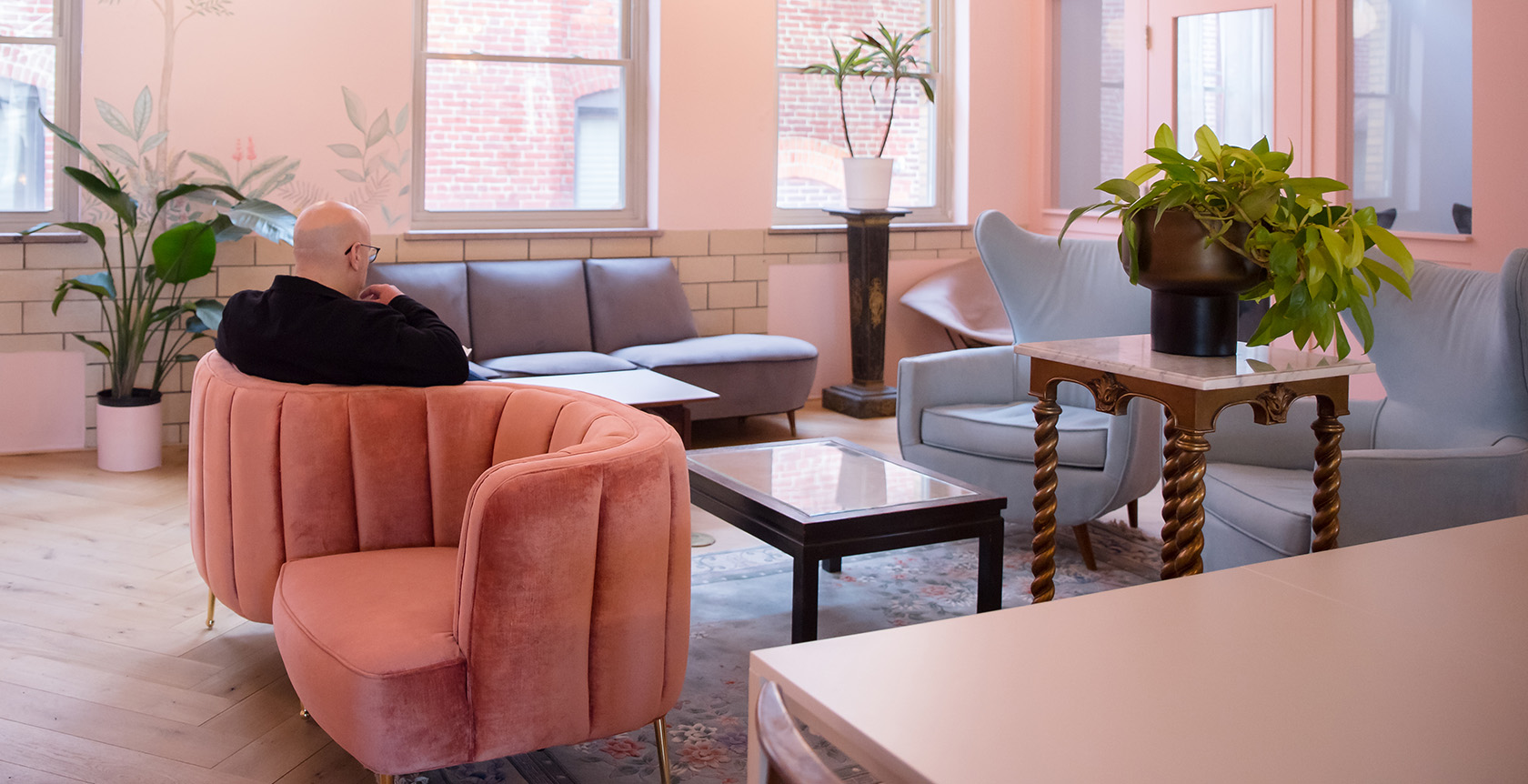 The Art Deco Miami Room at Fulton Commons coworking space Pittsburgh — pink lounge with velvet armchairs and botanical mural