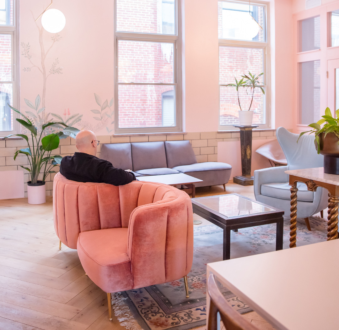 The Art Deco Miami Room at Fulton Commons coworking space Pittsburgh — pink lounge with velvet armchairs and botanical mural