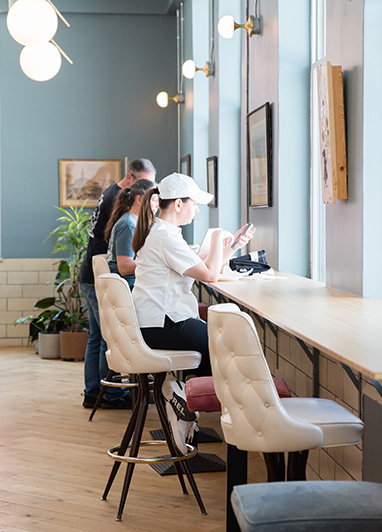 Day pass coworking at Fulton Commons Pittsburgh — counter seating along a sunlit window bar