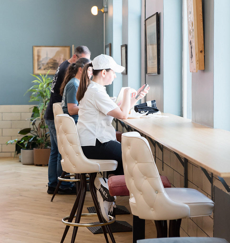 Day pass coworking at Fulton Commons Pittsburgh — counter seating along a sunlit window bar