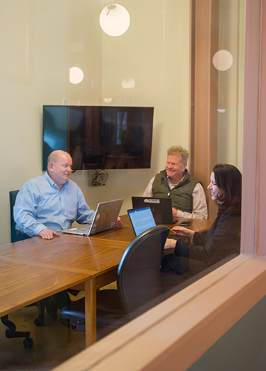 Meeting room at Fulton Commons Pittsburgh — conference table with screen and seating for a small group
