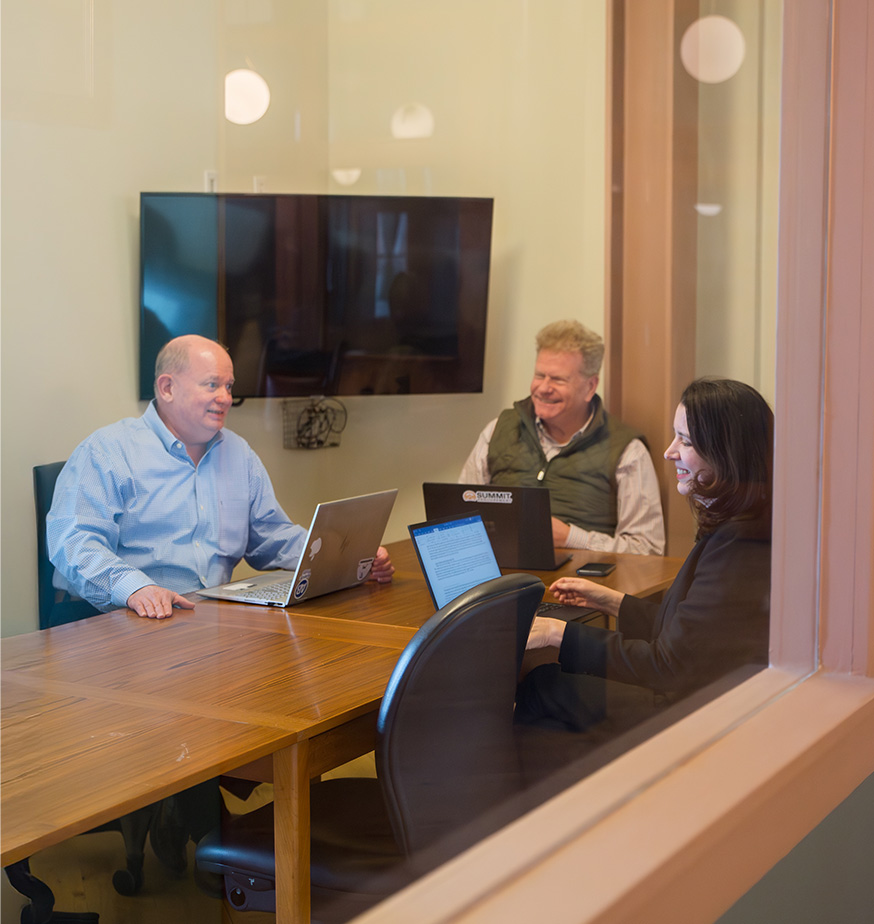 Meeting room at Fulton Commons Pittsburgh — conference table with screen and seating for a small group