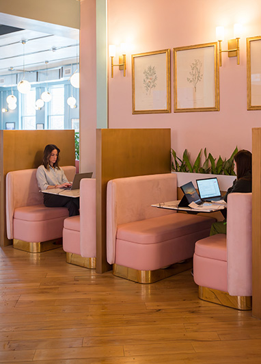 Open seating coworking membership at Fulton Commons Pittsburgh — pink lounge booths with natural light