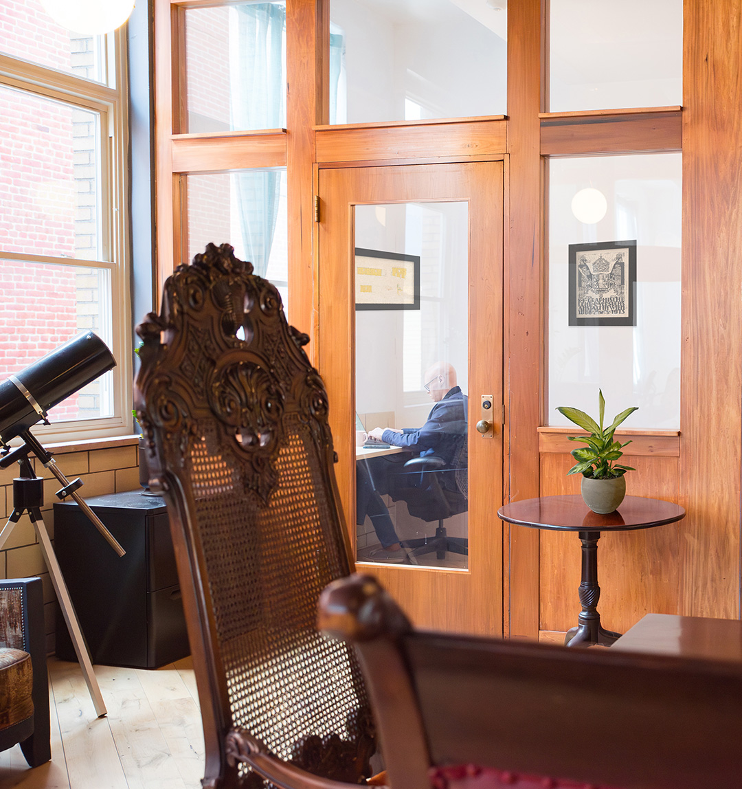 Member working in a private office with a glass door at Fulton Commons in Pittsburgh's Manchester neighborhood
