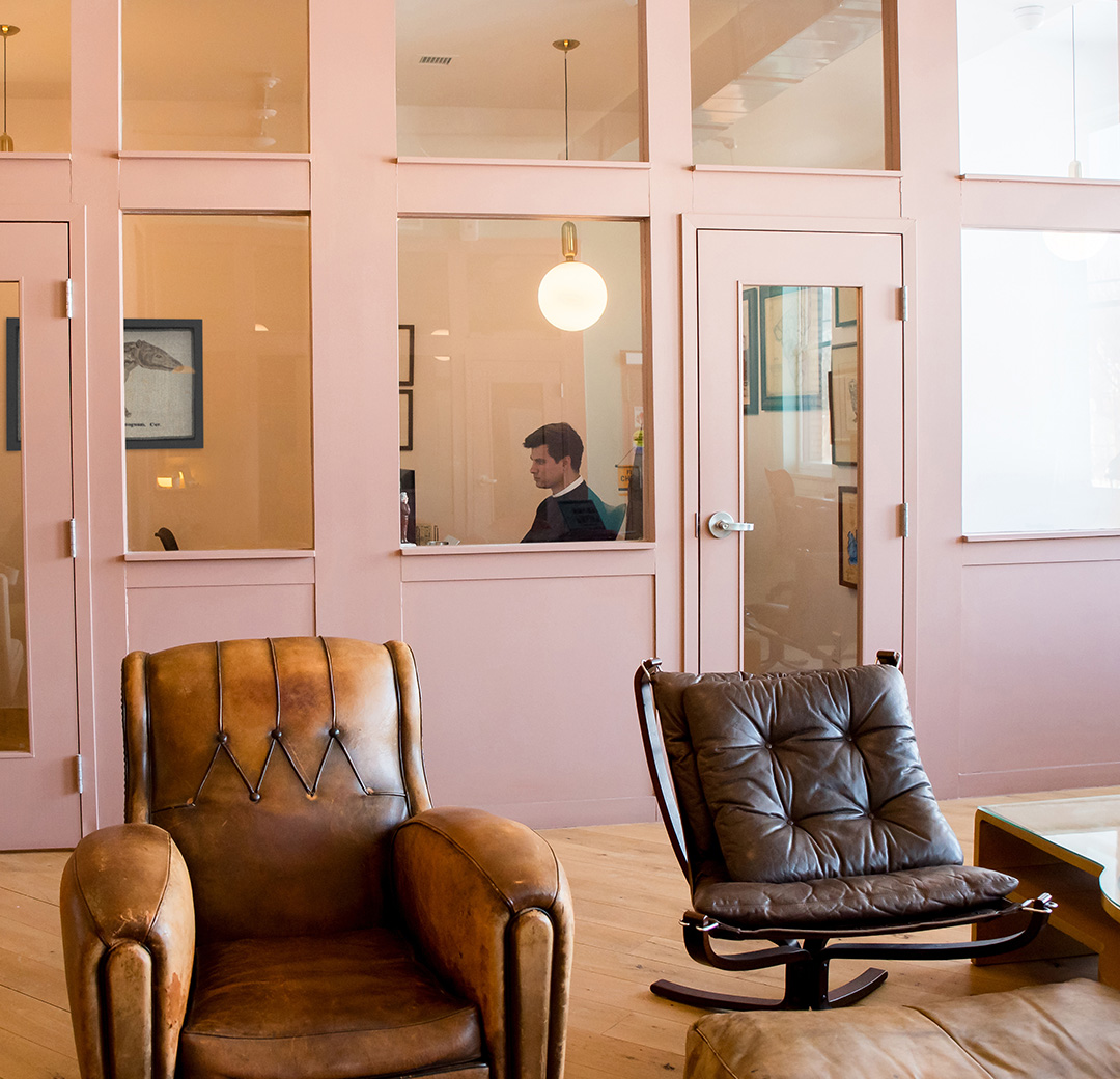 Private offices at Fulton Commons Pittsburgh, pink glass-walled offices with leather armchairs